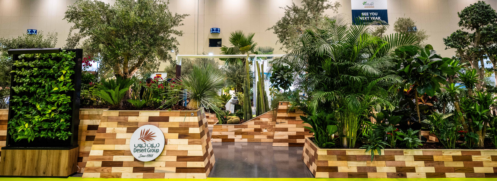 Desert Group feature planter Front at My Plant & Gardens Expo with in-house pallet wood carpentry, Plantscapes design, and Wahat Al Sahraa trees