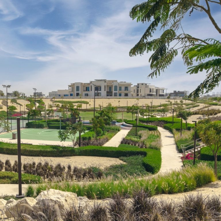 Modern residential community landscaping with walking paths, green lawns and native planting in the UAE